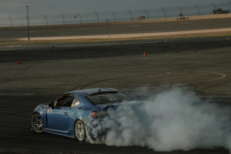 a blue car is doing soing with its engine burn