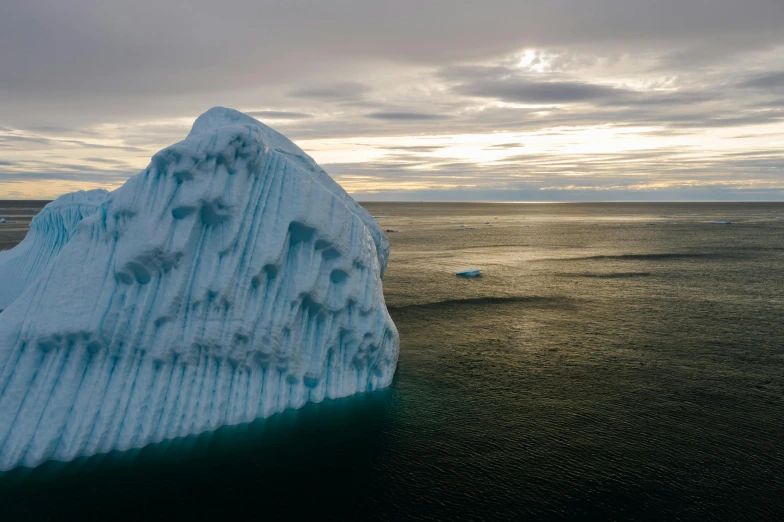 large iceberg in ocean with ice with snow on it