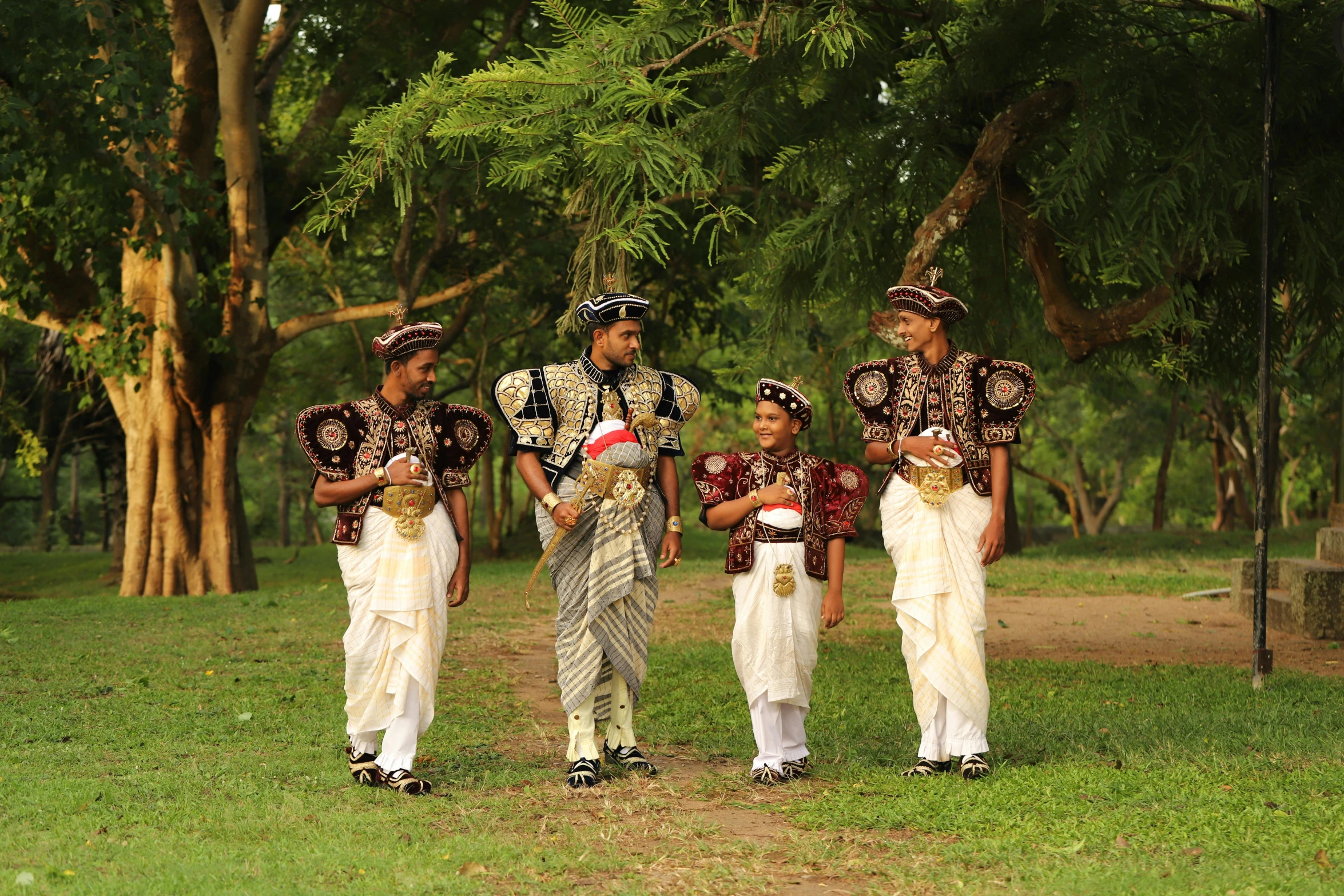 four male performers holding flowers are standing in the park