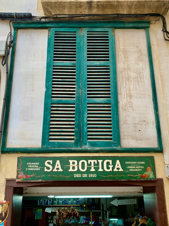 a storefront with green shutters sitting outside of it