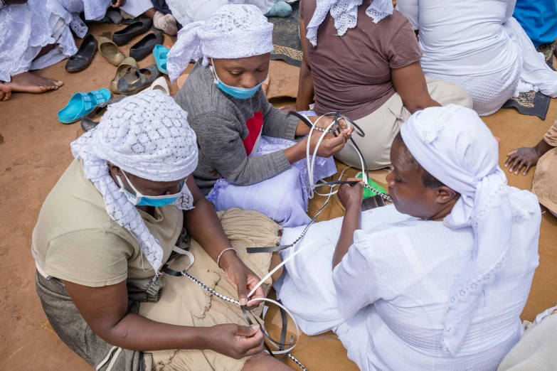 a group of people wearing white hats and holding wires