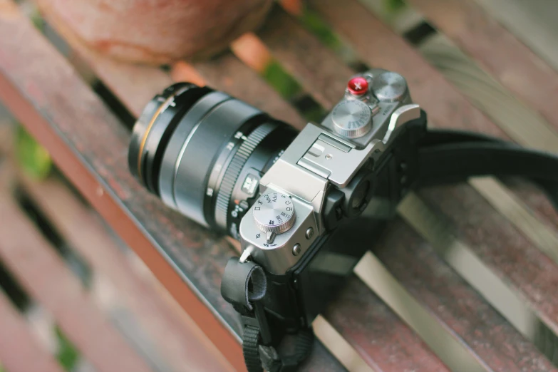 an old looking camera sitting on top of a wooden bench