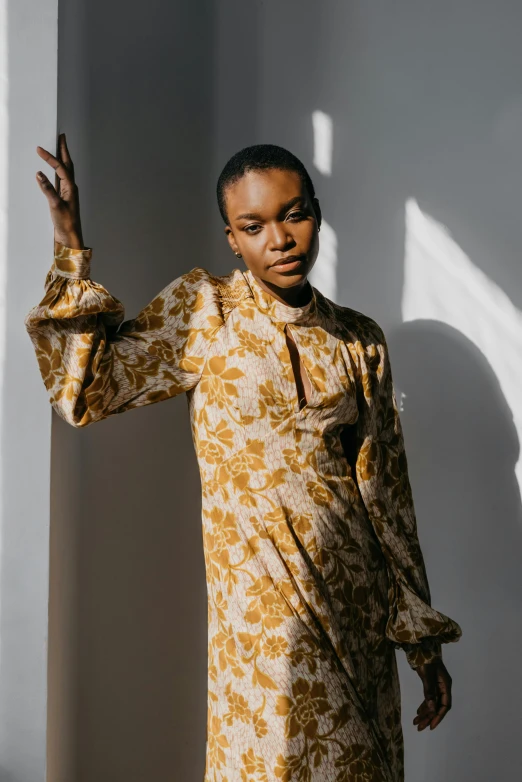 young woman dressed in a yellow dress making peace sign