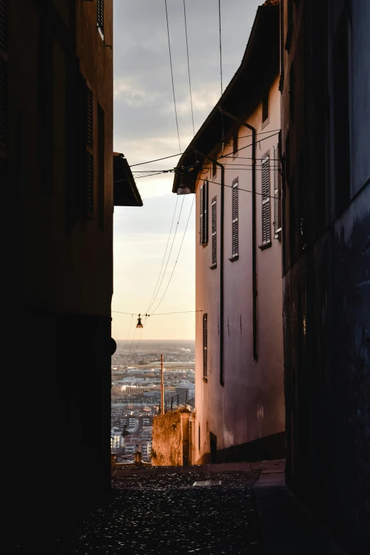 a narrow alley way with buildings facing the ocean