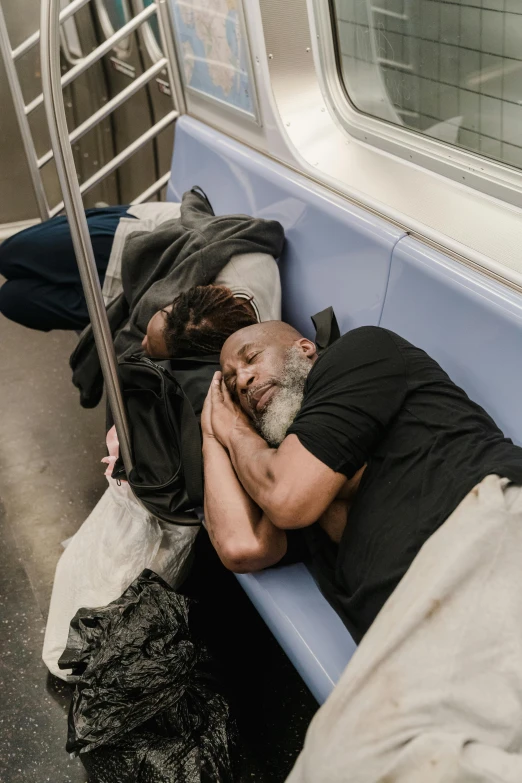 a man sleeps on a bus while holding his hands against the head