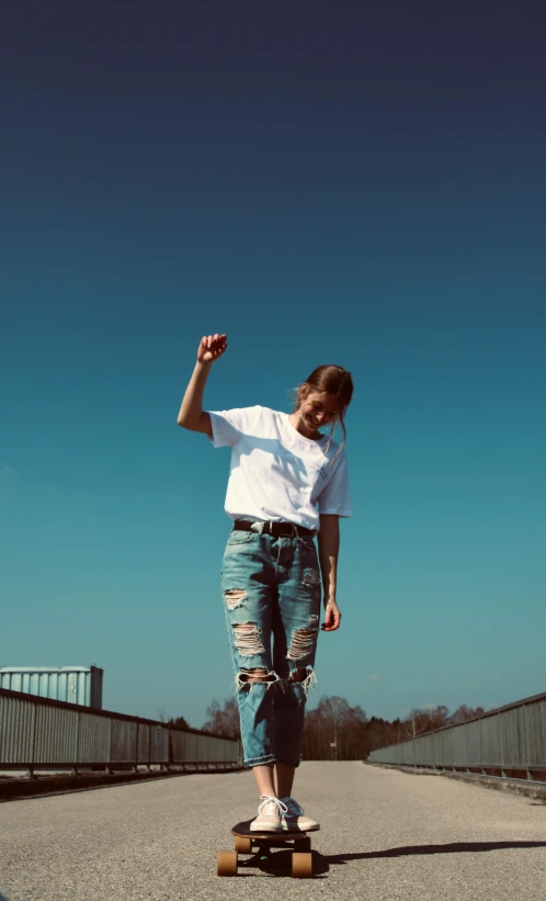 a young man riding a skateboard across a bridge