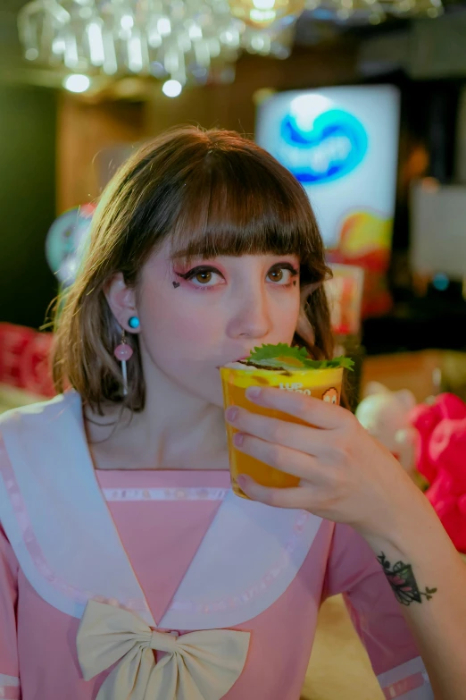 a girl with a bow tie holding a glass