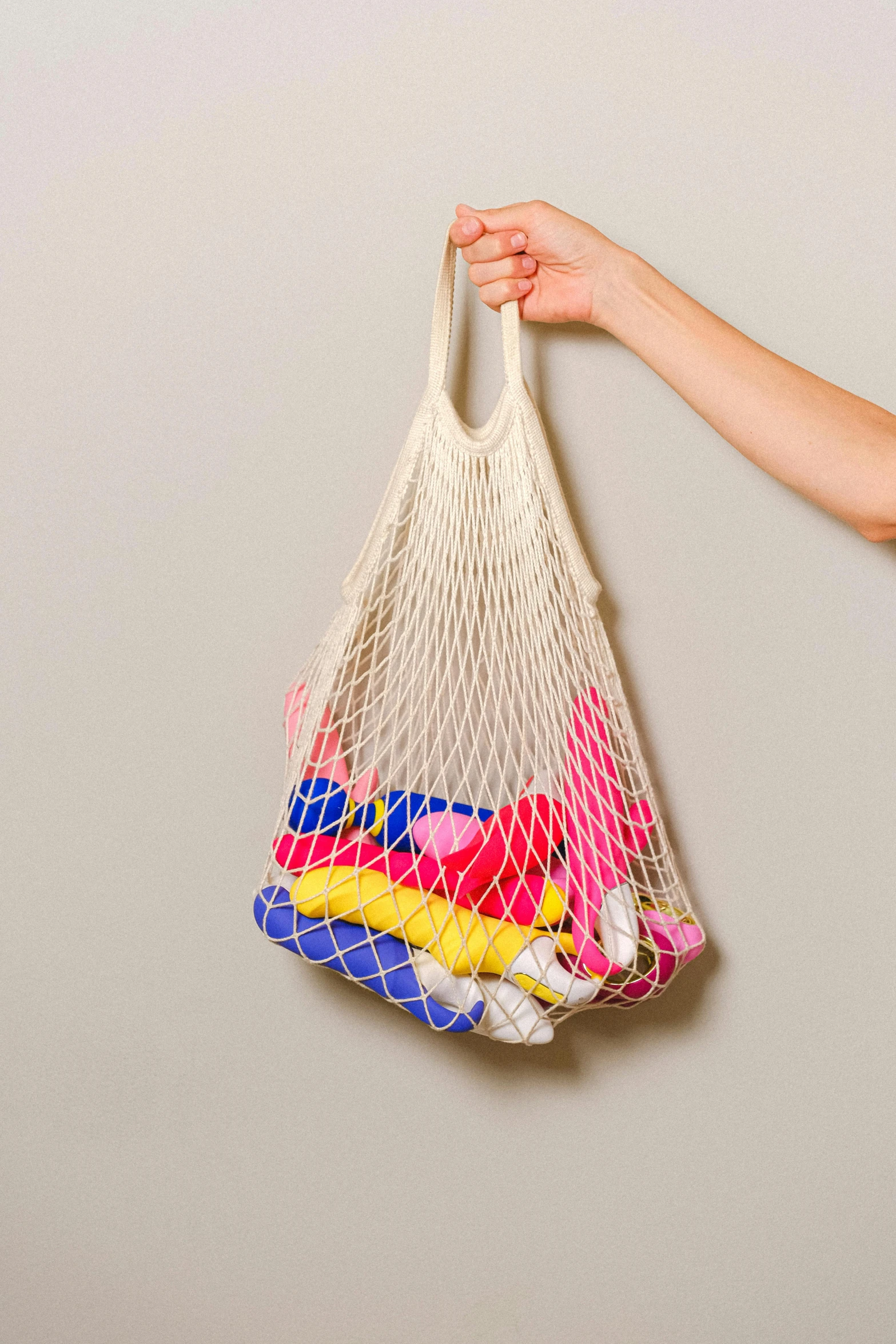 a hand holds a mesh bag full of laundry