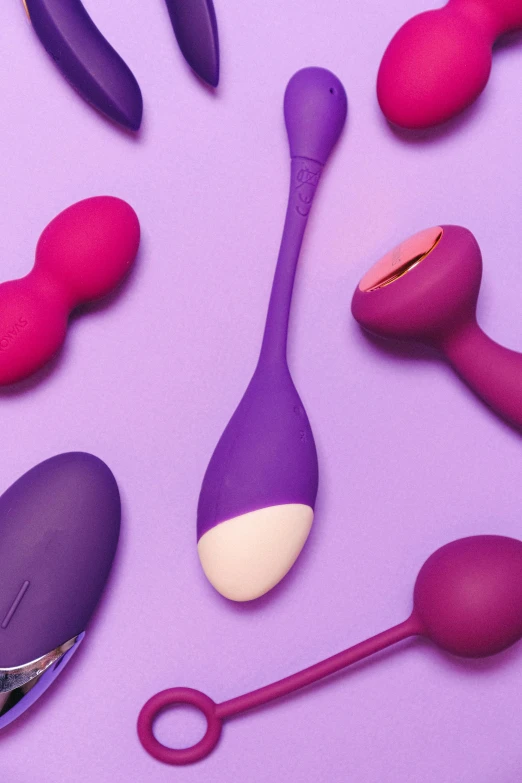 a pair of scissor heads, ear plugs and spoons in pink on a purple surface