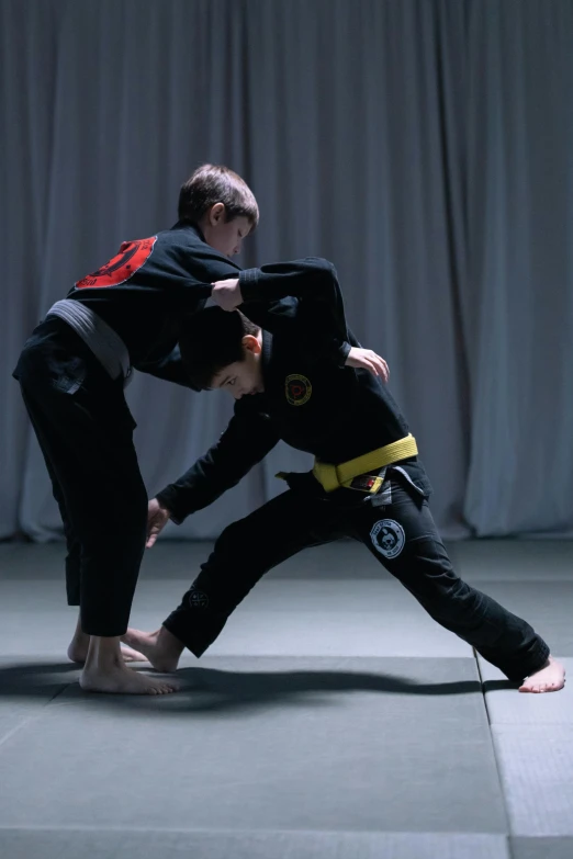 two people practicing martial moves in a dark room