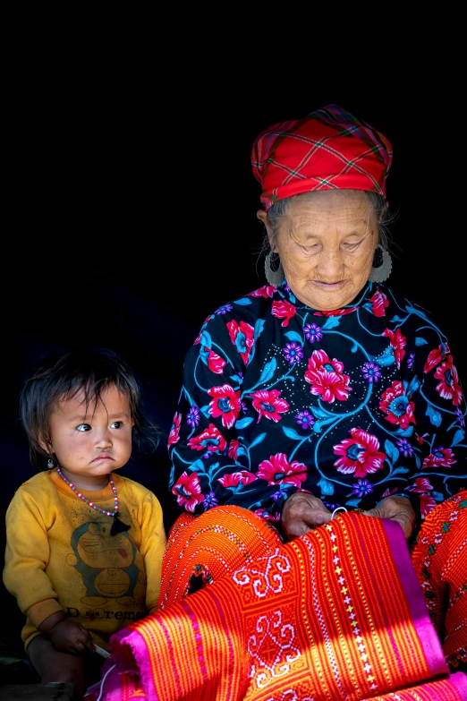 an elderly woman sitting next to a child