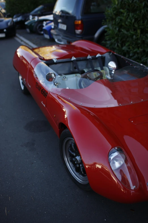 an older red car is on the side of the road