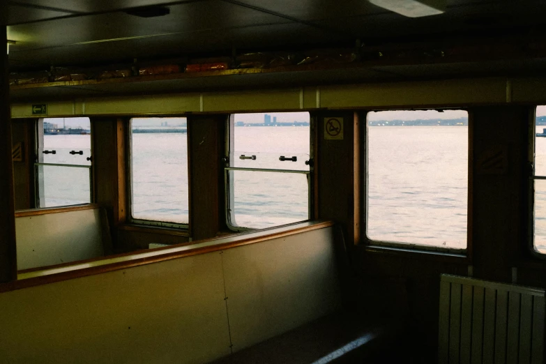 an empty dining car with multiple windows overlooking water