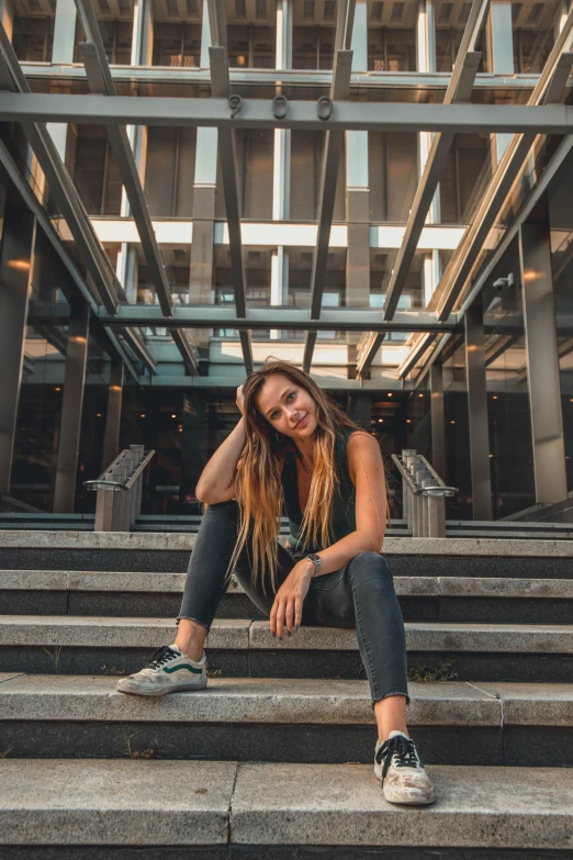 a girl in sneakers sitting on some stairs