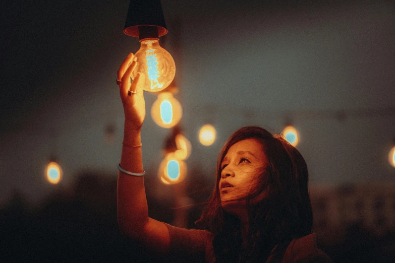 a woman is holding a lite up light bulb