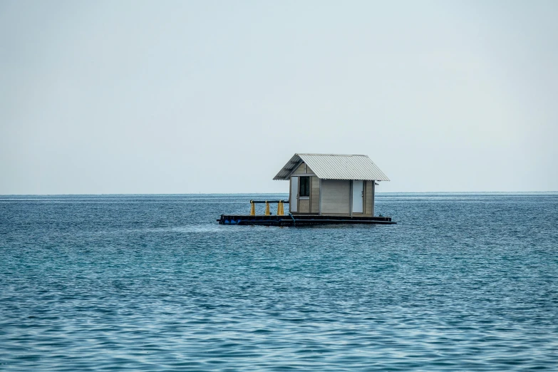 this is a house on a small raft in the middle of the ocean