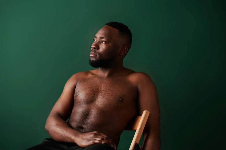 a shirtless man with a rocking chair in front of him