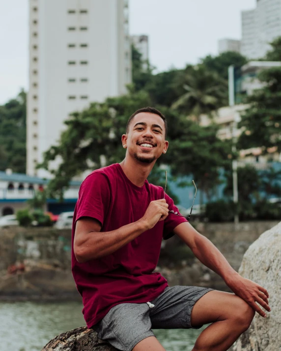 a man sitting on the side of a wall near the ocean