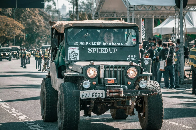 a military jeep drives down the street during an event