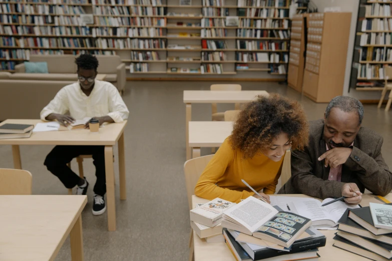 two people are sitting at tables writing in a liry