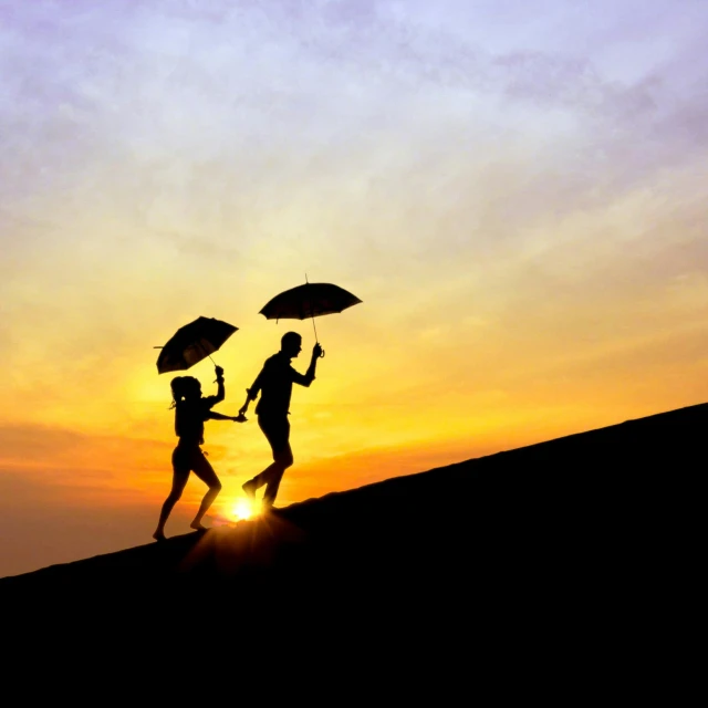 two people holding up umbrellas walking on a hill