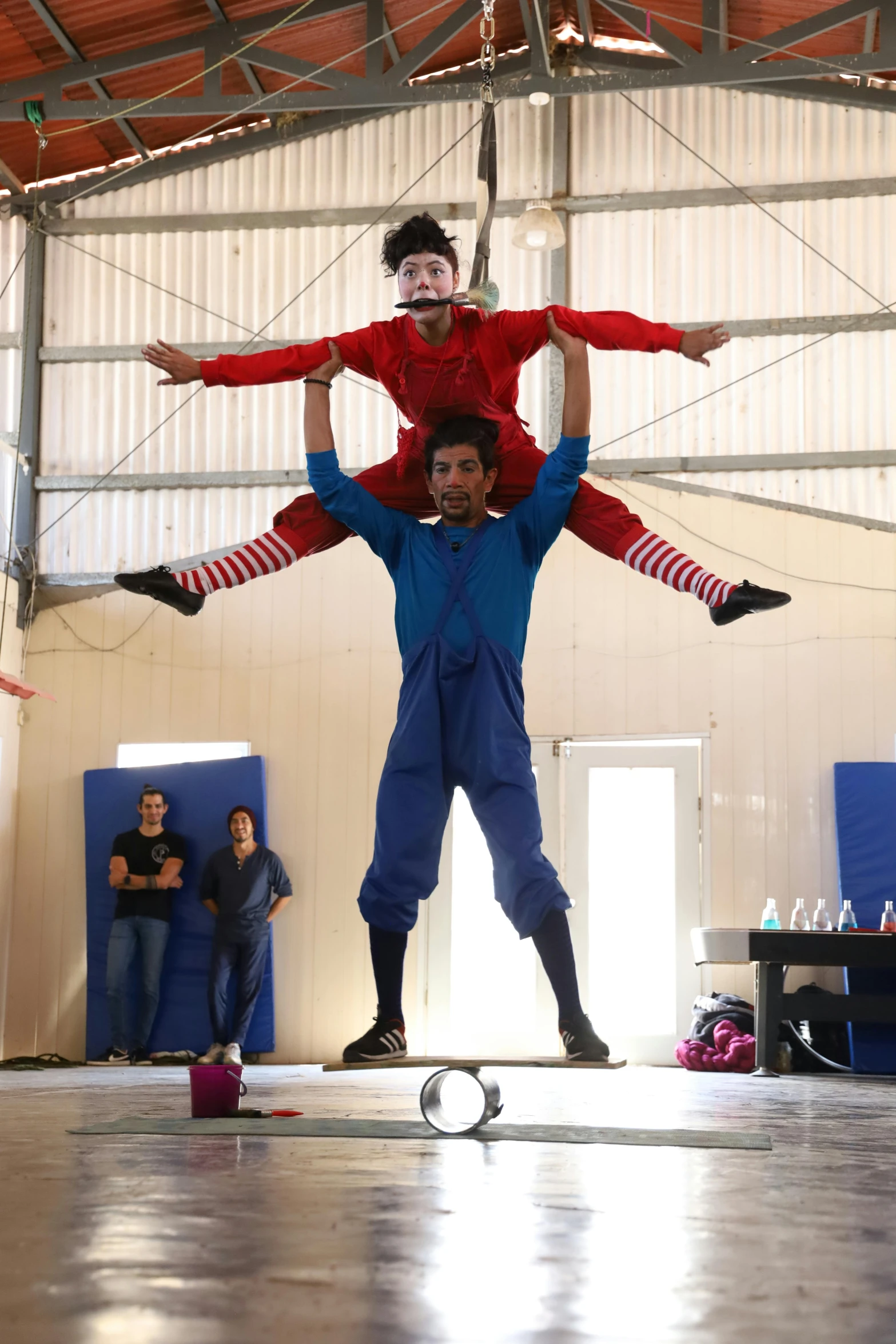 a man riding on top of another man in an indoor gym