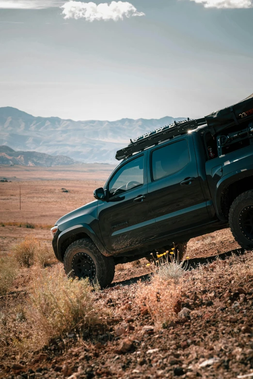 truck parked in field with mountains in the background