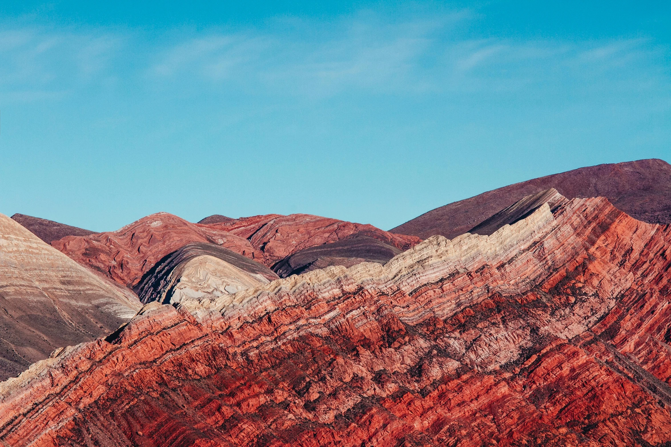 a few hills that have red and brown layers