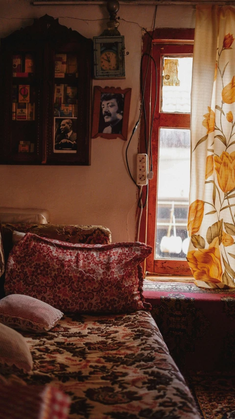 a bed in a bedroom next to a window with curtain