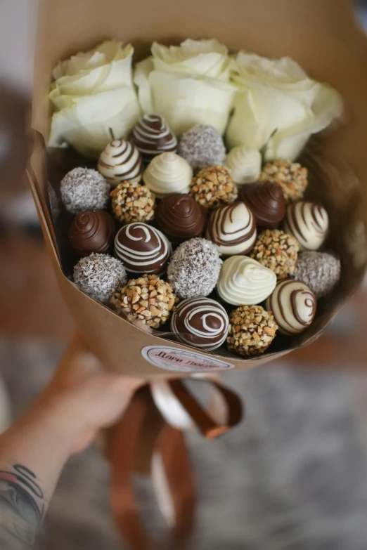 a bouquet of flowers and some chocolates wrapped in paper