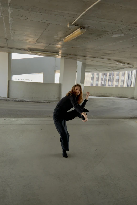 a person is practicing martial in an empty parking garage