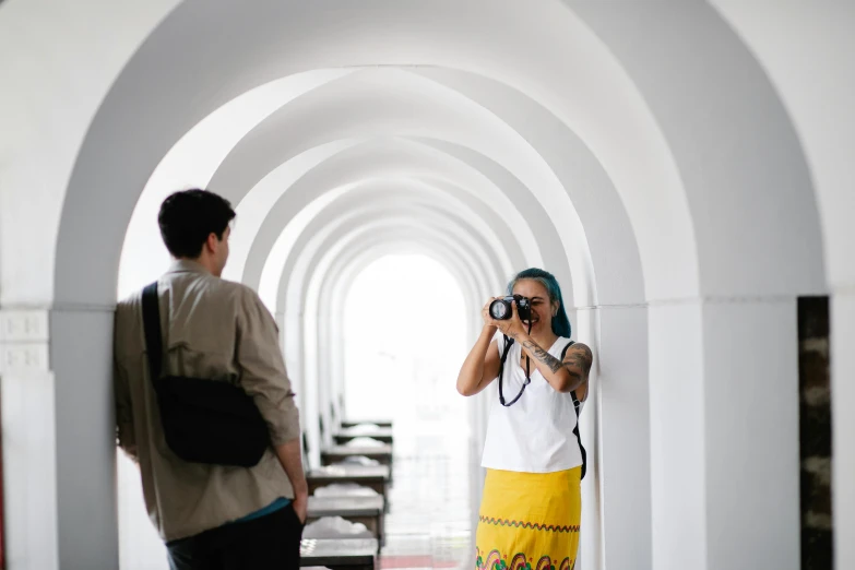 a woman standing in a hallway with a camera