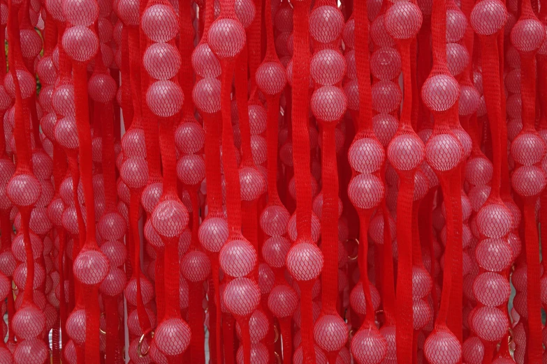 a red curtain with balls hanging from it