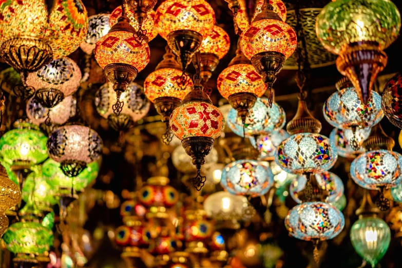 many different lights hanging in a store for decoration