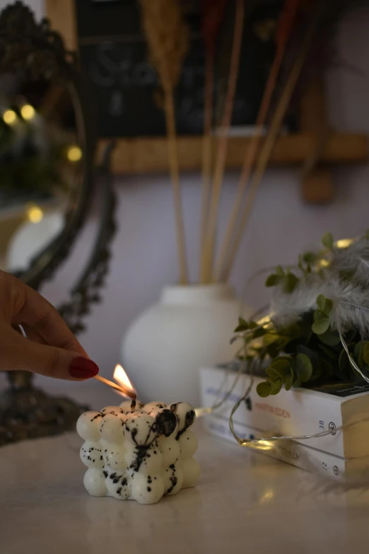 the person lights the candle next to their bouquet