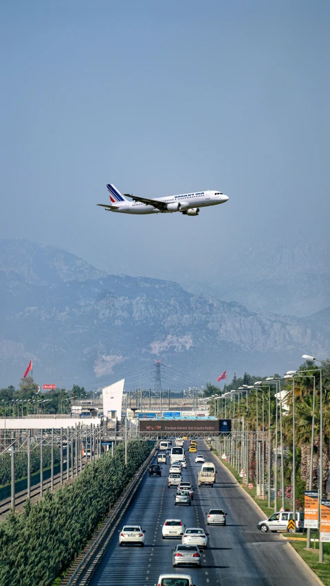 an airplane is coming in for a landing over the highway