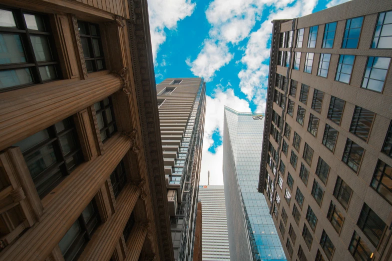 the top part of two tall buildings from below