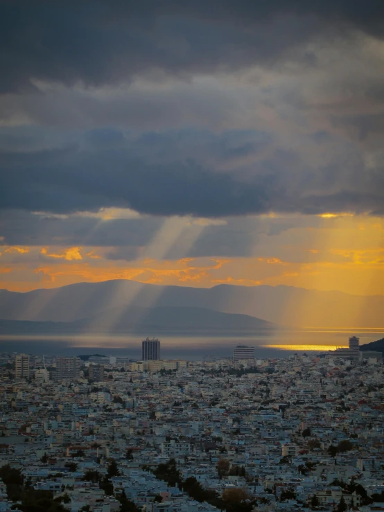 a view of the sun peeking through clouds over city