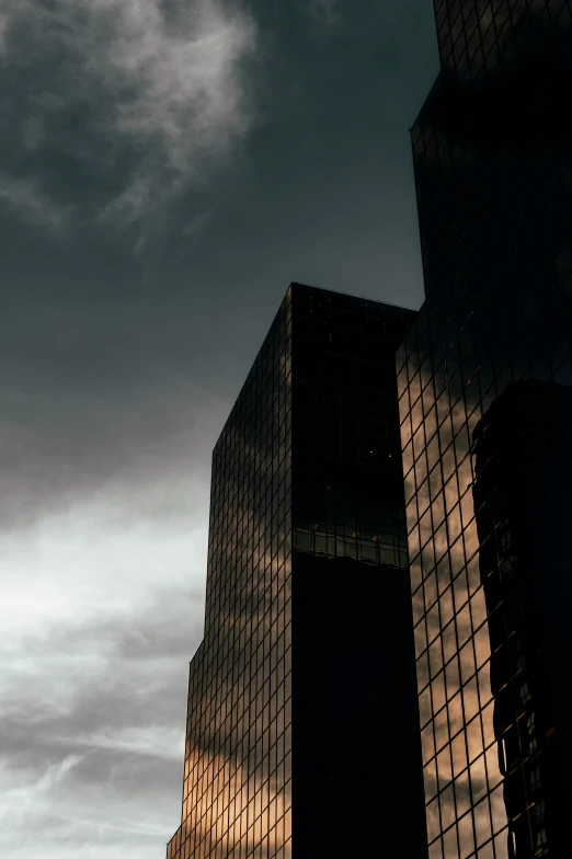 a jet flying in the sky past two tall buildings