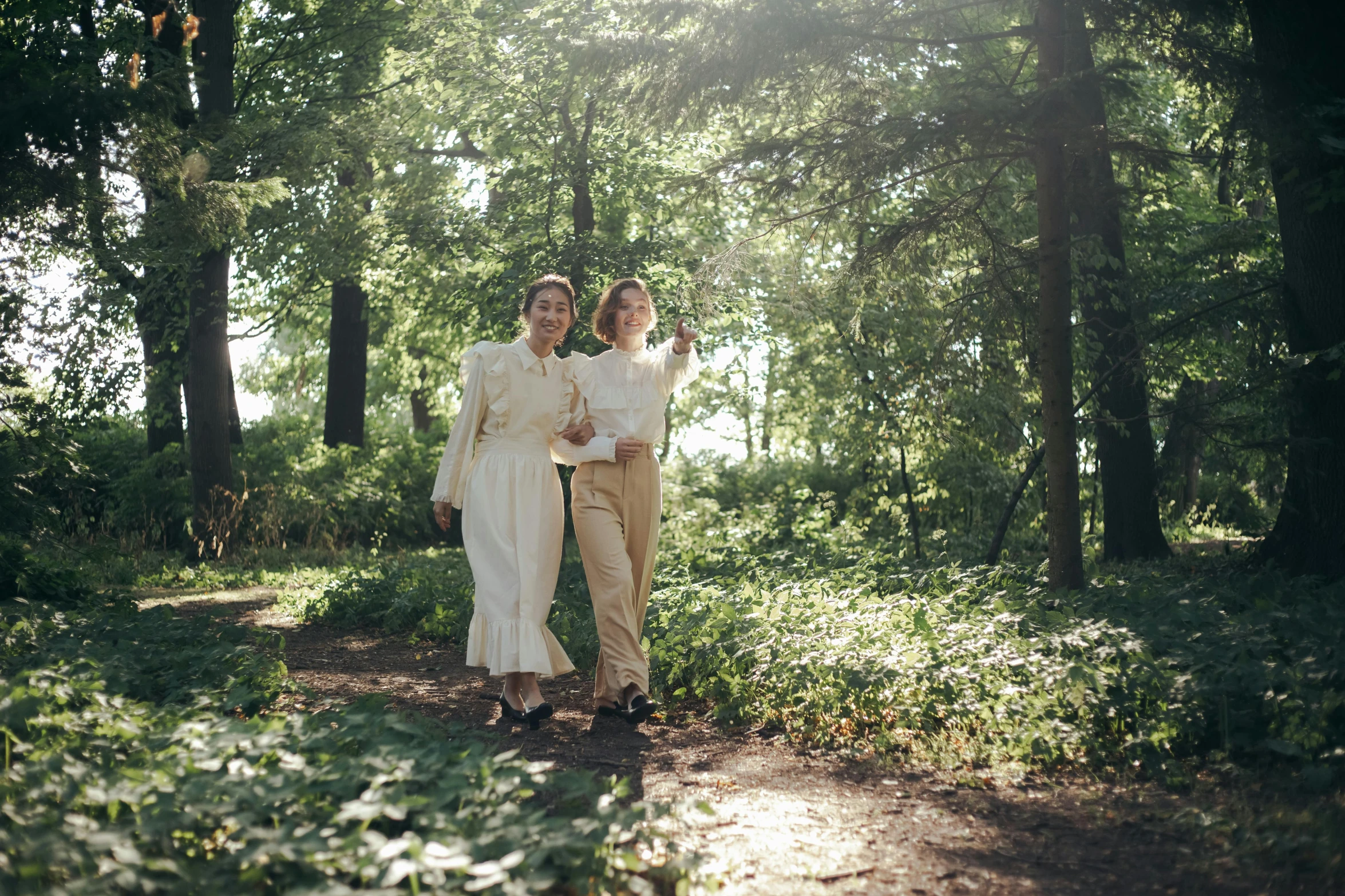 a couple is walking through the woods taking a selfie