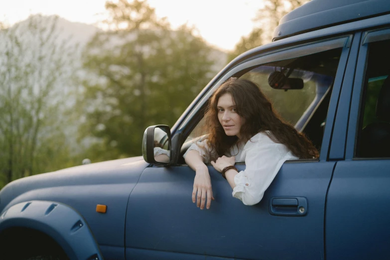 a woman leaning out the window of a pick up truck