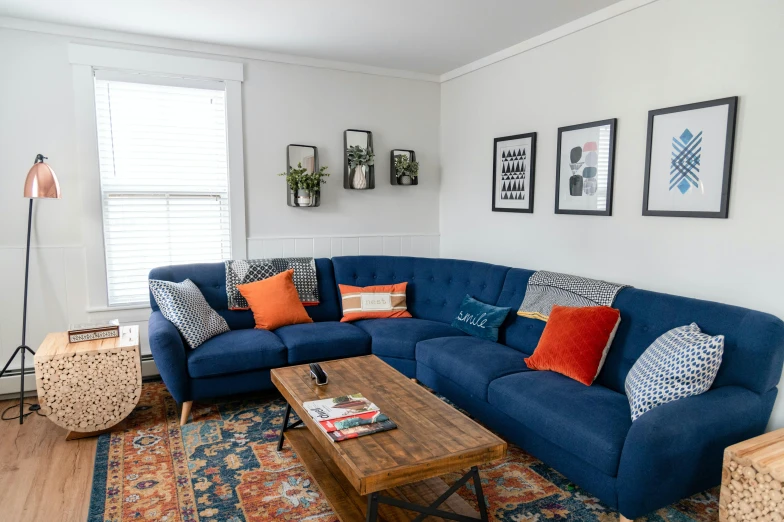 a living room filled with a blue sectional couch and two tables