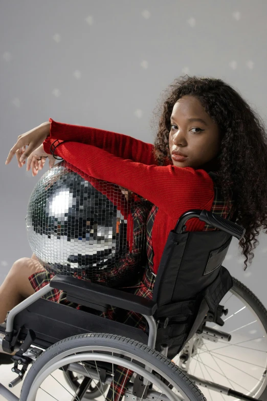 a woman in a wheelchair holding a disco ball