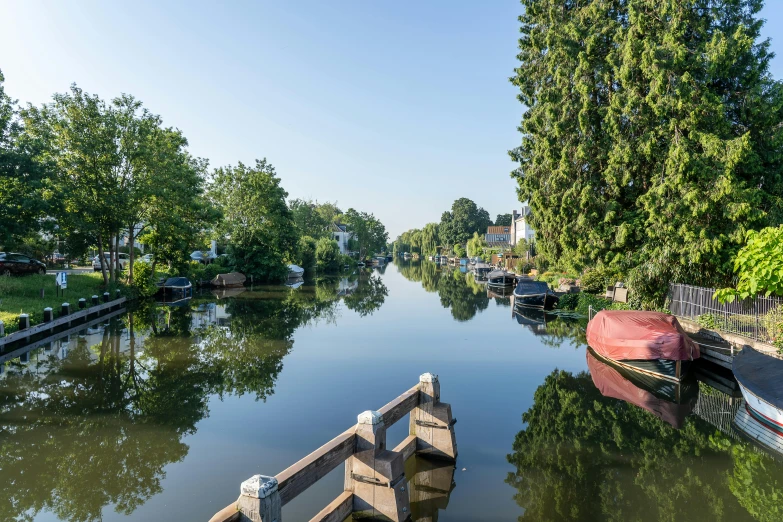 a narrow river is shown as a barge travels by