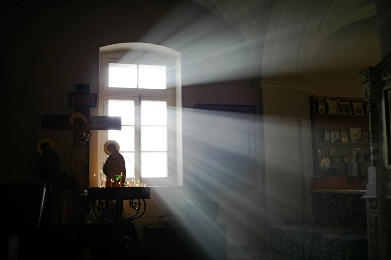 a child is standing under a window, with light coming through the window