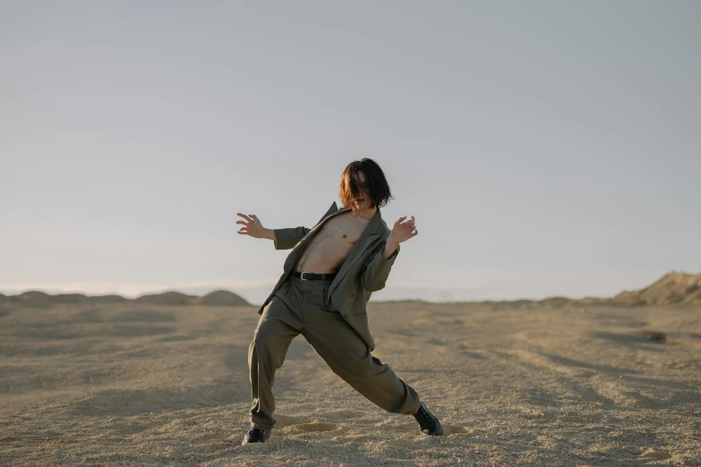 man in a desert with outstretched legs posing for the camera