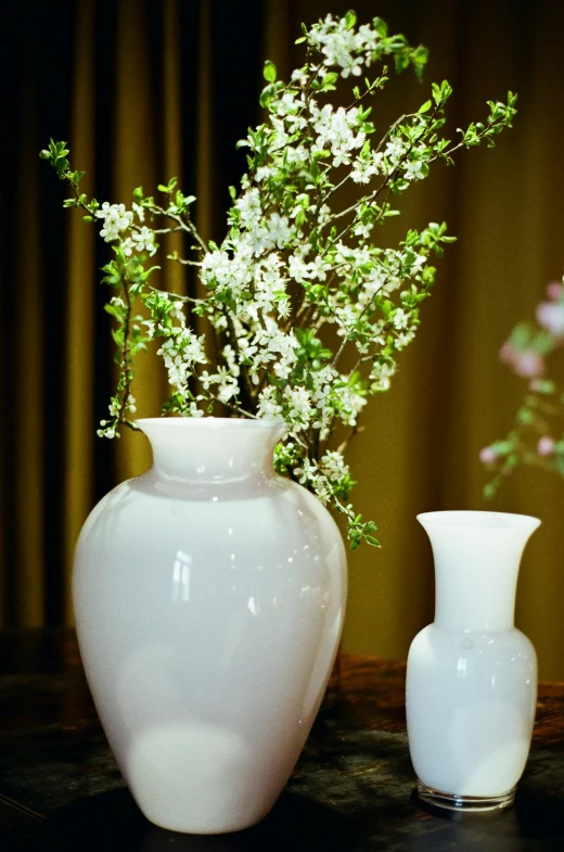 two white vases are sitting on a table