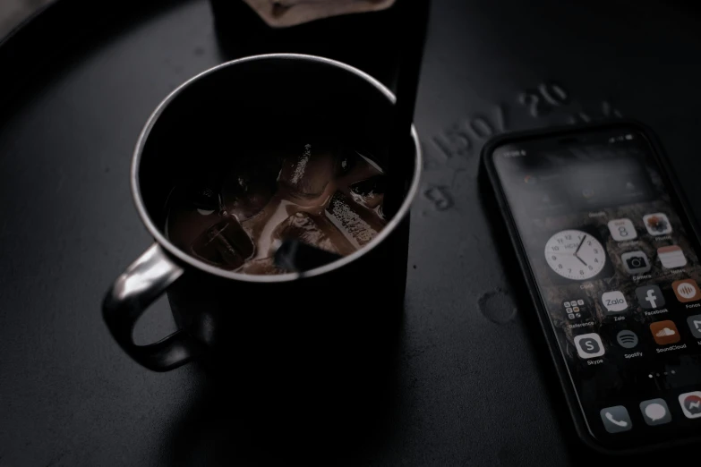 an image of a coffee cup with dessert on it and the cell phone beside it