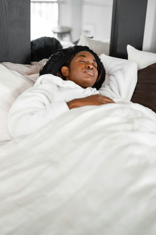 a woman laying on her bed with her eyes closed