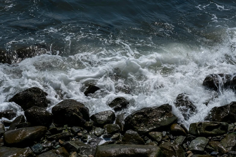 the waves on the rocks are crashing into shore